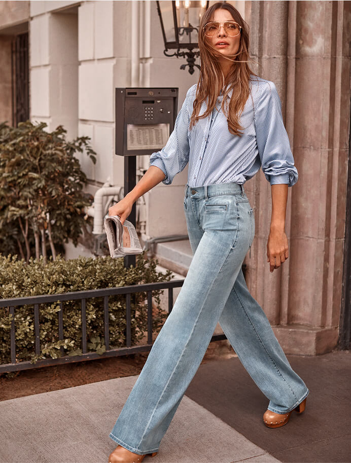 Model walking out of a building wearing items from cabi's Fall 2025 Collection